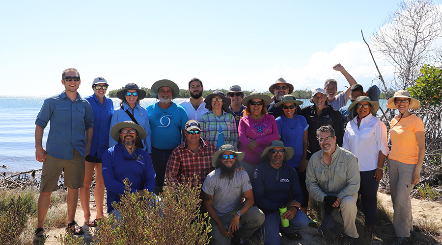 Els científics posen davant de l'aigua al nostre taller de plantació d'herbes marines a Puerto Rico