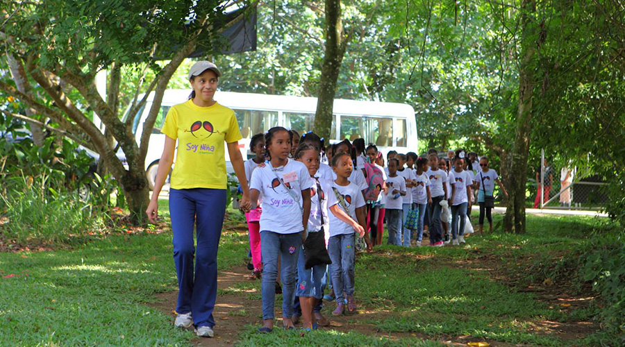 Young girls and camp counselor walk hand in hand