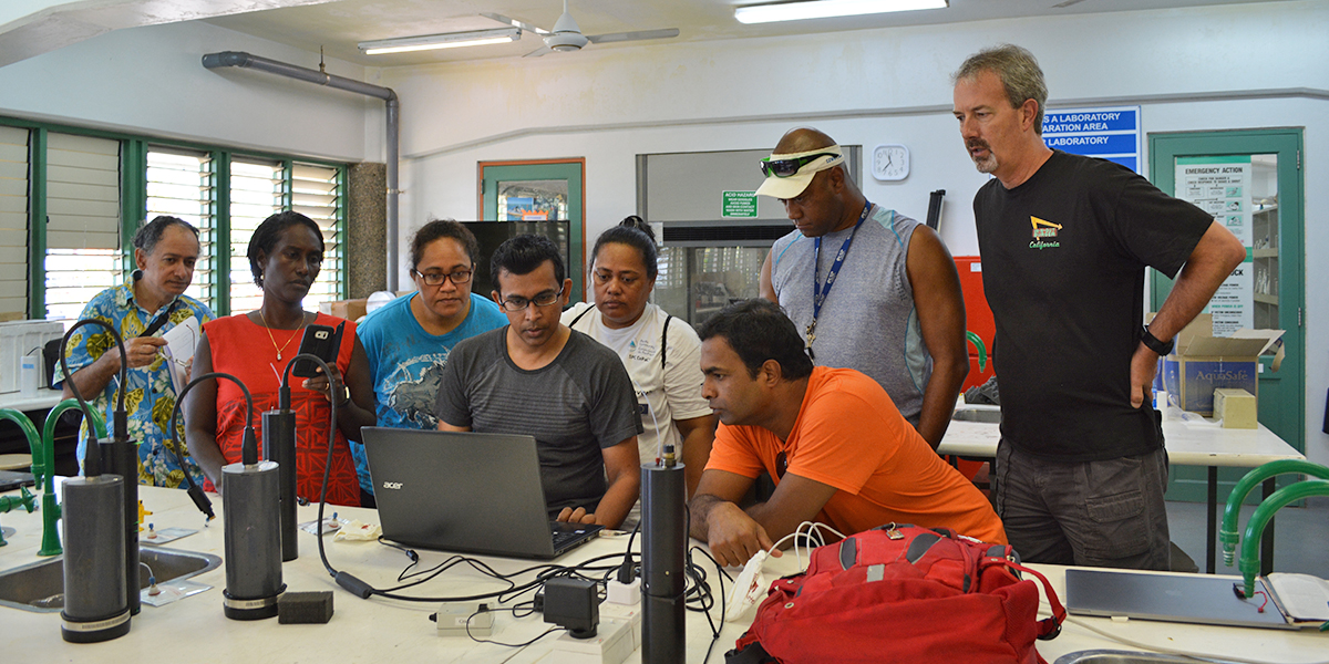 Scientists at our Ocean Acidification Monitoring Workshop in Fiji check water samples in the lab.