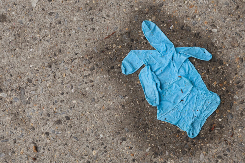 Plastic glove discarded on sidewalk
