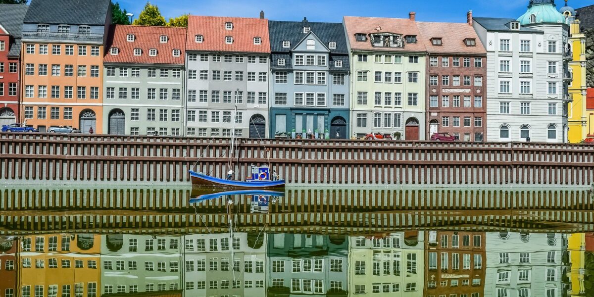 Houses lined up in a row with water in front of them, in a town in northern Europe