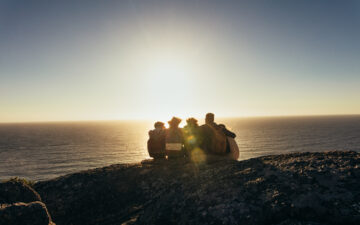 Friends admiring the sunset from mountain top