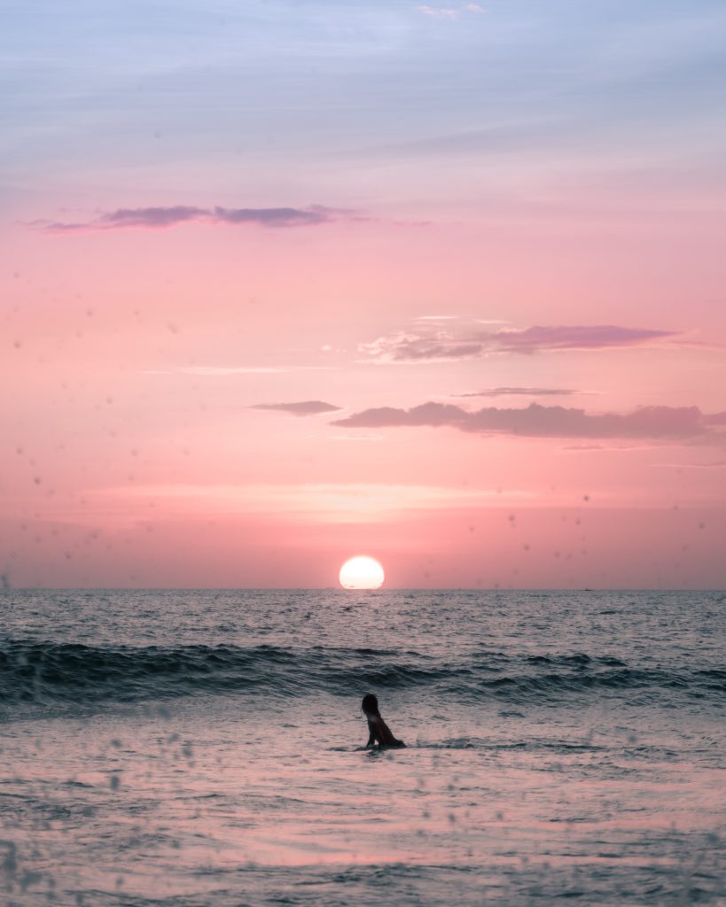 Research and Development: person in the ocean wading in the sunset