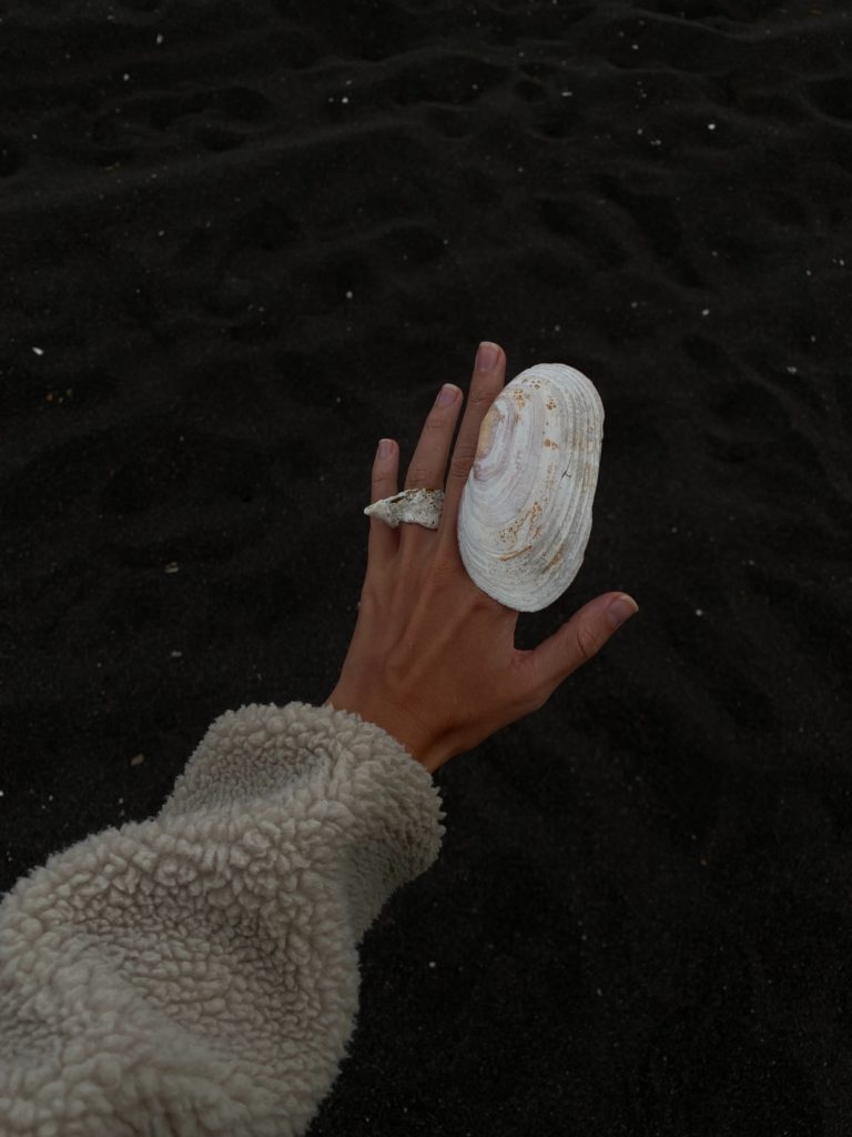 woman's hand touching a shell