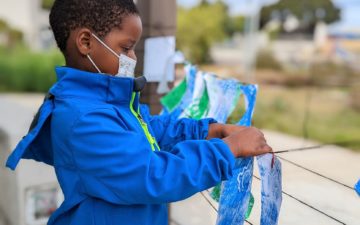 Community Ocean Engagement: Child works on a piece of ocean art outside