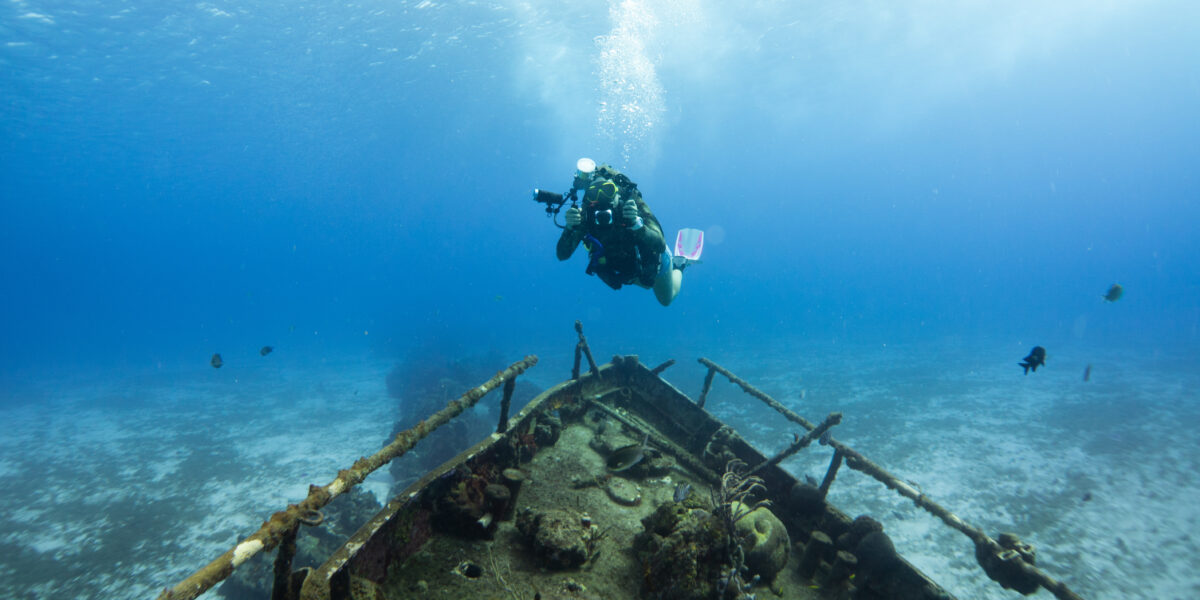 Ship wreck underwater in Cozumel Mexico, scuba diver exploring the scene