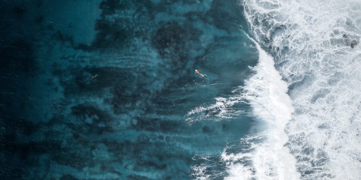 Ariel shot of the ocean and a surfer