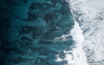 Ariel shot of the ocean and a surfer