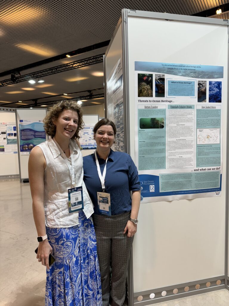 Charlotte Jarvis and Maddie Warner stand with their poster on “Threats to Our Ocean Heritage,” discussing Potentially Polluting Wrecks, Bottom Trawling, and Deep Seabed Mining.