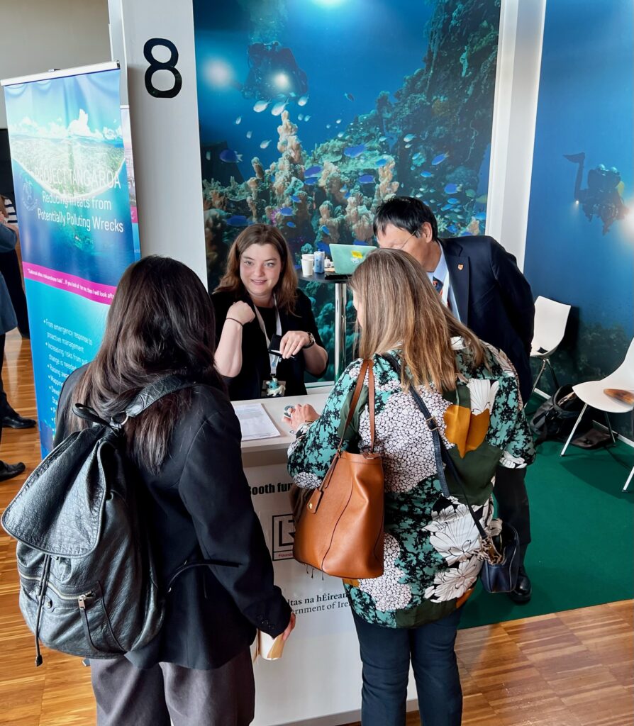 Maddie Warner talking with visitors at TOF's Underwater Cultural Heritage booth at the 2024 UN Ocean Decade Conference.