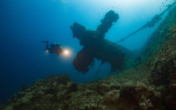 Potápač skúma podmorský vrak.