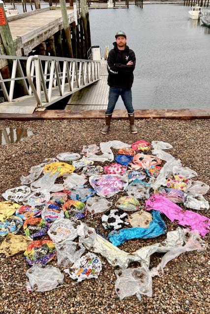 Kapitein Nate Severdija staat bij de Mylar-ballonnen die hij 'ving' tijdens een seizoen van vischarters voor de kust van Cape Cod, Massachusetts.