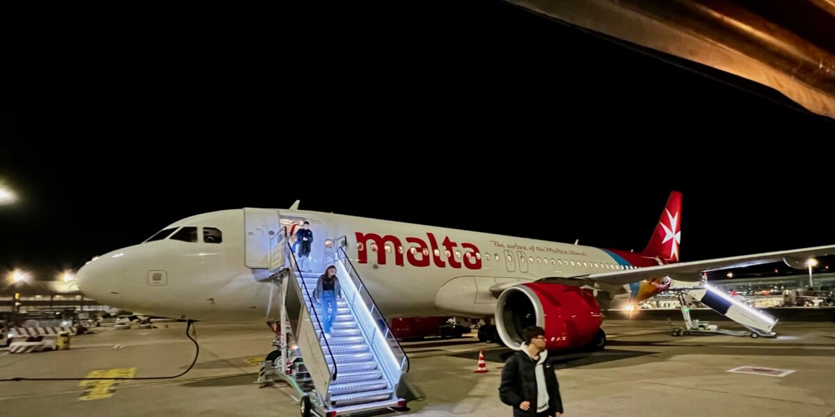 Un avion blanc avec des lettres rouges qui épellent Malte.