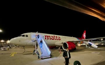 A white plane with red lettering that spells Malta.