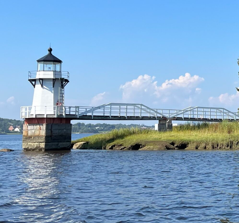 Farol no final de uma pequena passarela de ponte.