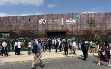 People walking into a building with a signthat says COP30 Brasil Amazonia.